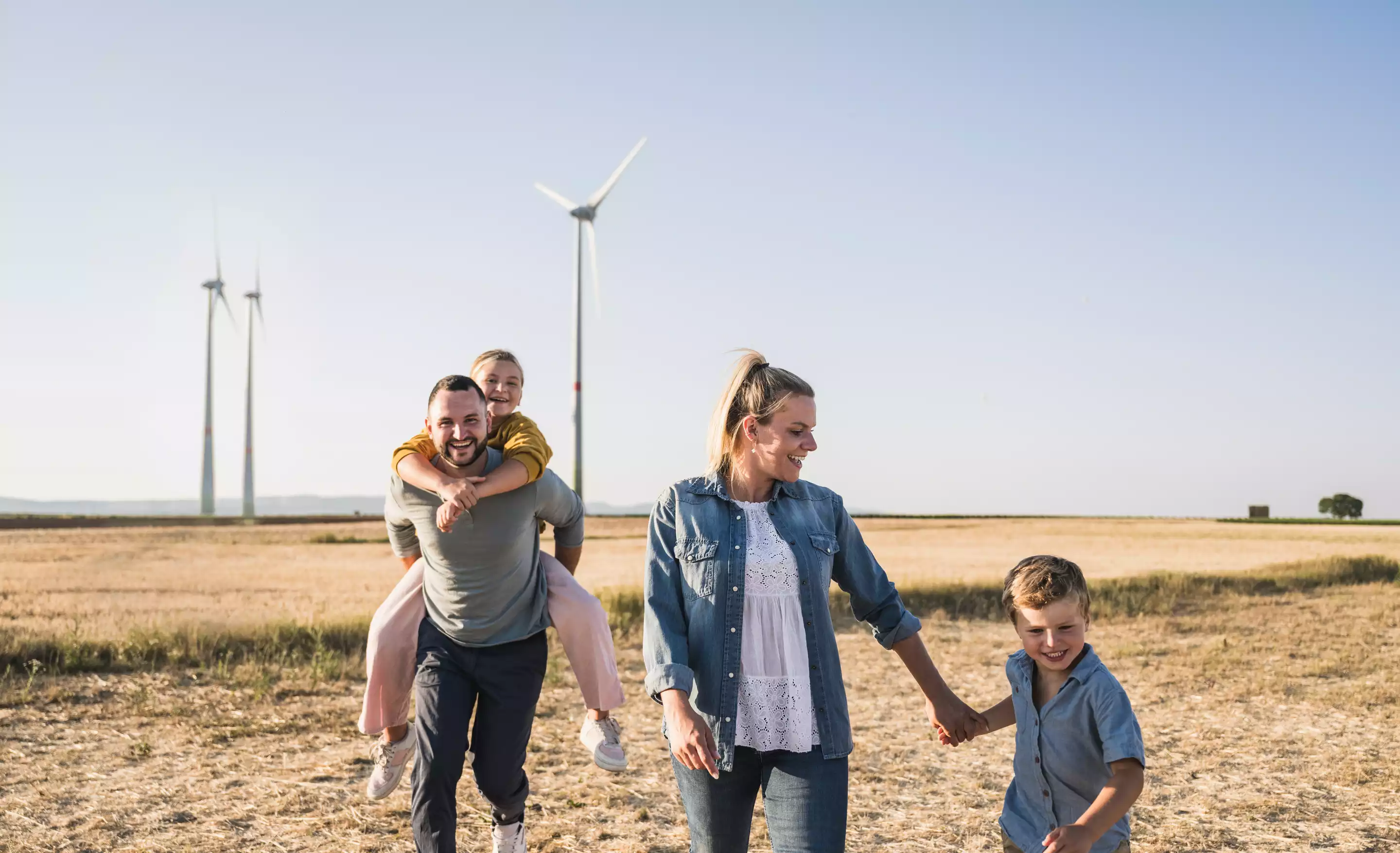 Familie in der Natur mit Windanlage im Hintergrund