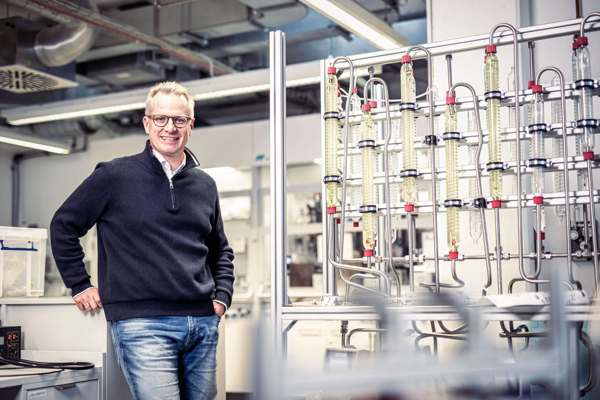 Foto eines lächelnden Mannes in einer Industrieanlage.